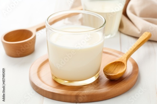 warm milk and honey in a clear cup with a spoon