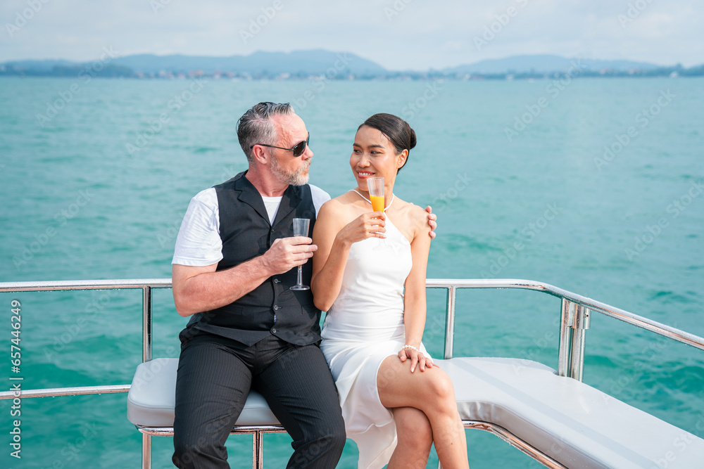 Happy couple in love sitting and drinking together on Yacht having fun in a sunny day, Summer holiday sea people concept.