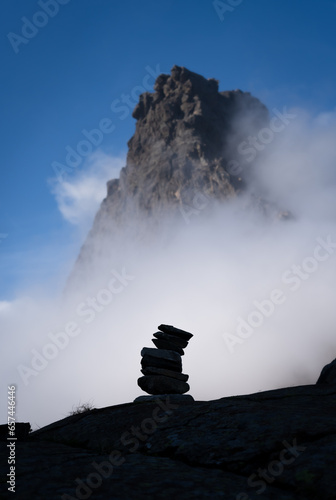 A cairn and clouds in the mountains.