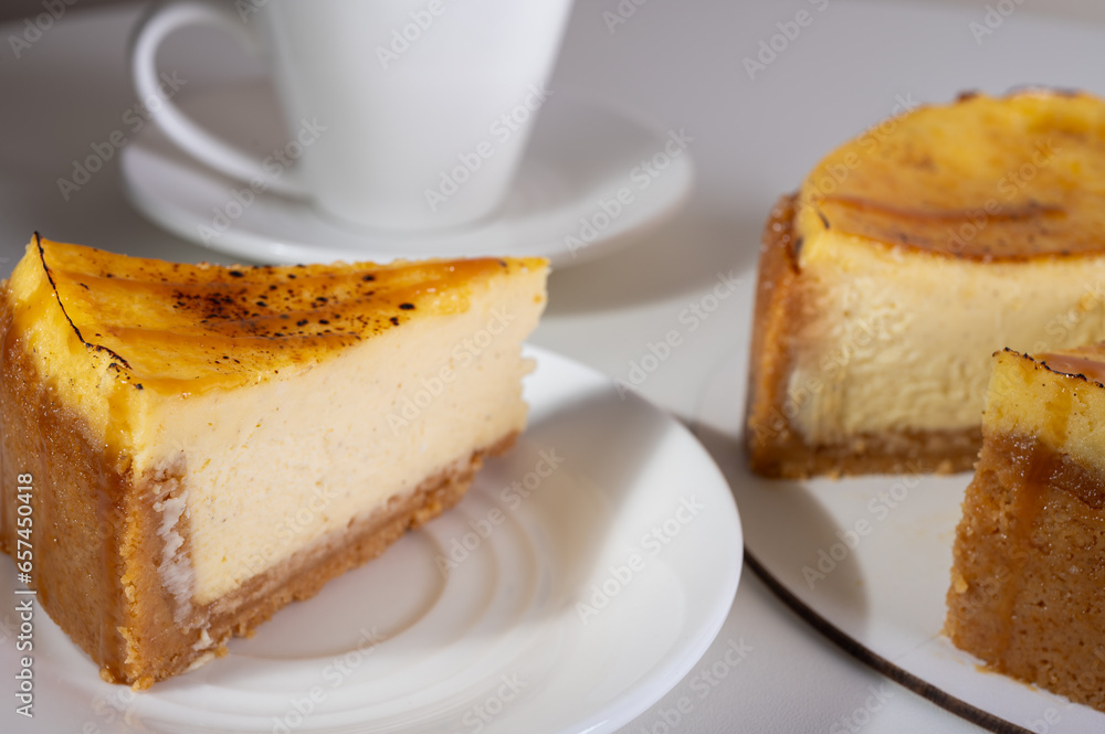cheese cheesecake with a crust, cut into a piece, on a light dish, background, with a cup of coffee. Preparation of cakes and pastries cheese cheesecake with a crust, cut into a piece, on a light dish, background, with a cup of coffee. Preparation of cakes and pastries