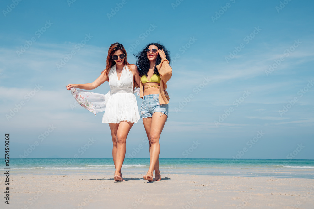 Happy couple woman in bikini walking and playing together on the beach having fun in a sunny day, Beach summer holiday sea people concept. Happy couple woman in bikini walking and playing together on the beach having fun in a sunny day, Beach summer holiday sea people concept.