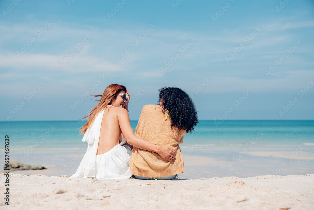Happy couple woman in bikini sitting and playing together on the beach having fun in a sunny day, Beach summer holiday sea people concept. Happy couple woman in bikini sitting and playing together on the beach having fun in a sunny day, Beach summer holiday sea people concept.