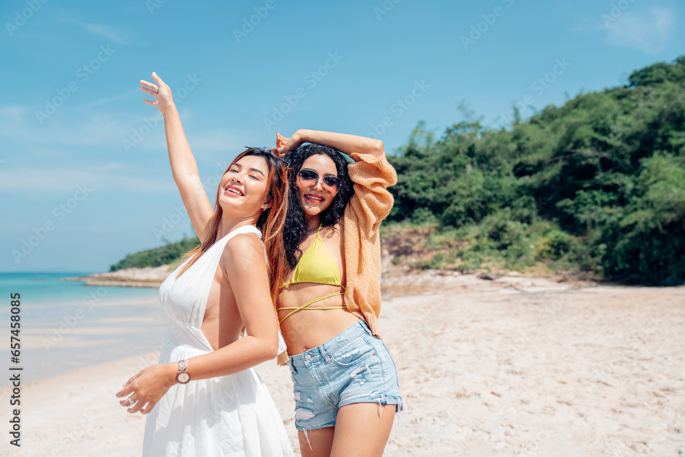 Happy couple woman in bikini walking and playing together on the beach having fun in a sunny day, Beach summer holiday sea people concept.
