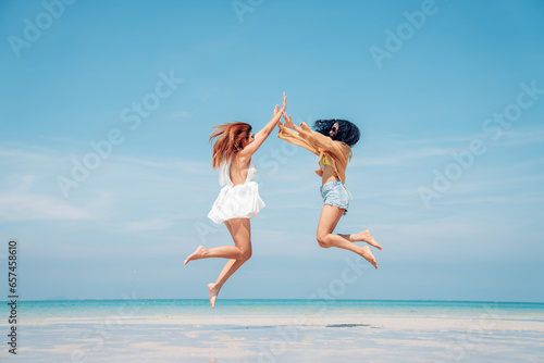 Happy couple woman in bikini walking and playing together on the beach having fun in a sunny day, Beach summer holiday sea people concept.