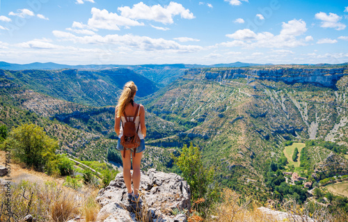 Young woman standing on cliff enjoying panoramic landscape mountain view- travel, adventure, hiking, tour tourism
