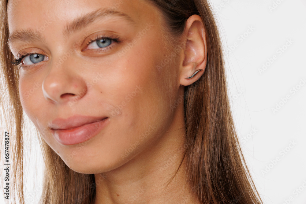 Beautiful young girl with fresh healthy skin. Woman advertise ear-rings. White background. Earrings, ear caffs closeup. Blond european woman with long hair with big lips, pretty smile. Cosmetology Beautiful young girl with fresh healthy skin. Woman advertise ear-rings. White background. Earrings, ear caffs closeup. Blond european woman with long hair with big lips, pretty smile. Cosmetology
