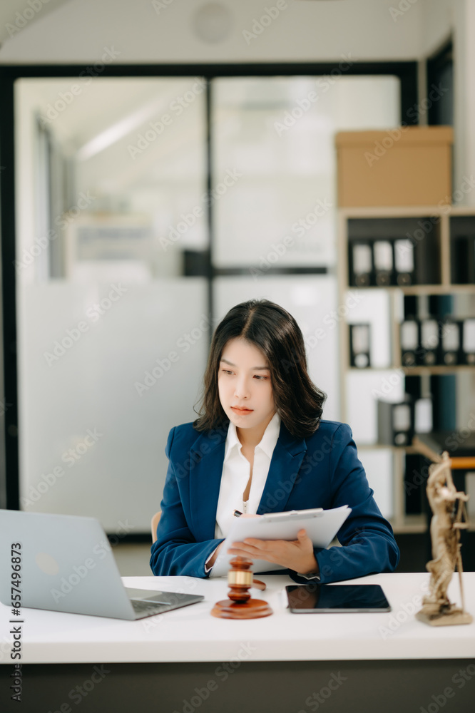 Asian lawyer woman working with a laptop and tablet in a law office. Legal and legal service concept. Asian lawyer woman working with a laptop and tablet in a law office. Legal and legal service concept.