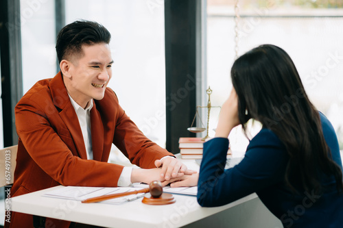 Business people compassionately holding hands and discussing contract papers with laptop and tabletat office room.. photo