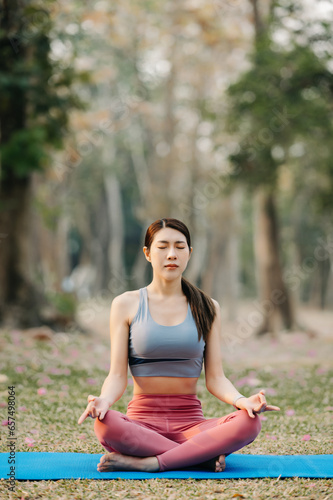 Wallpaper Mural Portrait of young woman practicing yoga in garden.female happiness.  in the park blurred background. Healthy lifestyle and relaxation concept. Torontodigital.ca