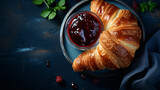French croissant. Freshly baked croissants with jam on dark stone background with coffe. Tasty croissants with copy space.
