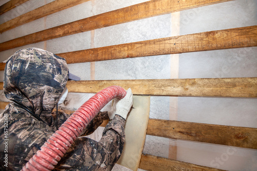 Blowing ecowool into a wall in a frame house photo