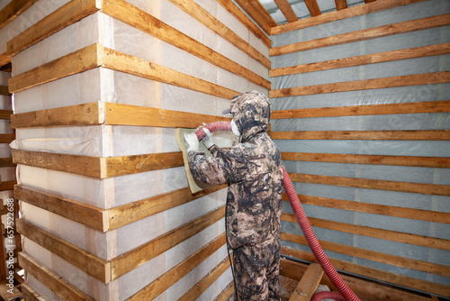 Blowing ecowool in a frame house into the wall through a hose
