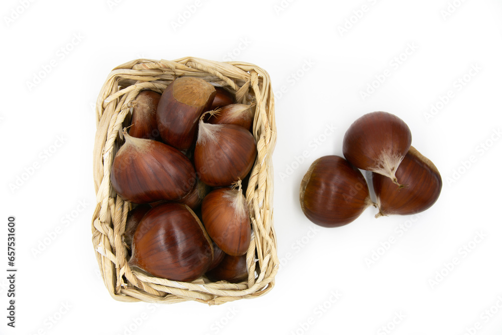 Chestnuts isolated on white background in a wicker basket full of chestnuts. Top view. Chestnuts isolated on white background in a wicker basket full of chestnuts. Top view.