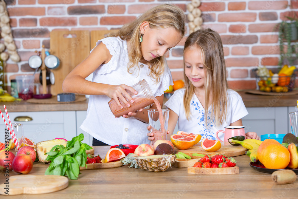 Two little girls in the kitchen with fresh vegetables. Healthy food concept. Happy sisters.