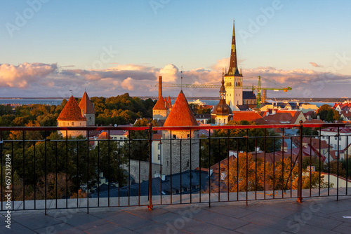 Classic Tallinn cityscape with Saint Olaf's church and old town walls and towers at autumn sunset, Estonia photo