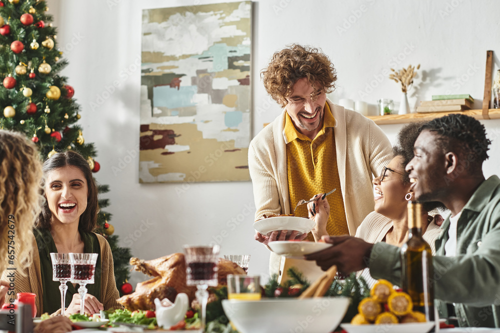 big cheerful multicultural family sitting at Christmas table laughing and enjoying holiday feast big cheerful multicultural family sitting at Christmas table laughing and enjoying holiday feast