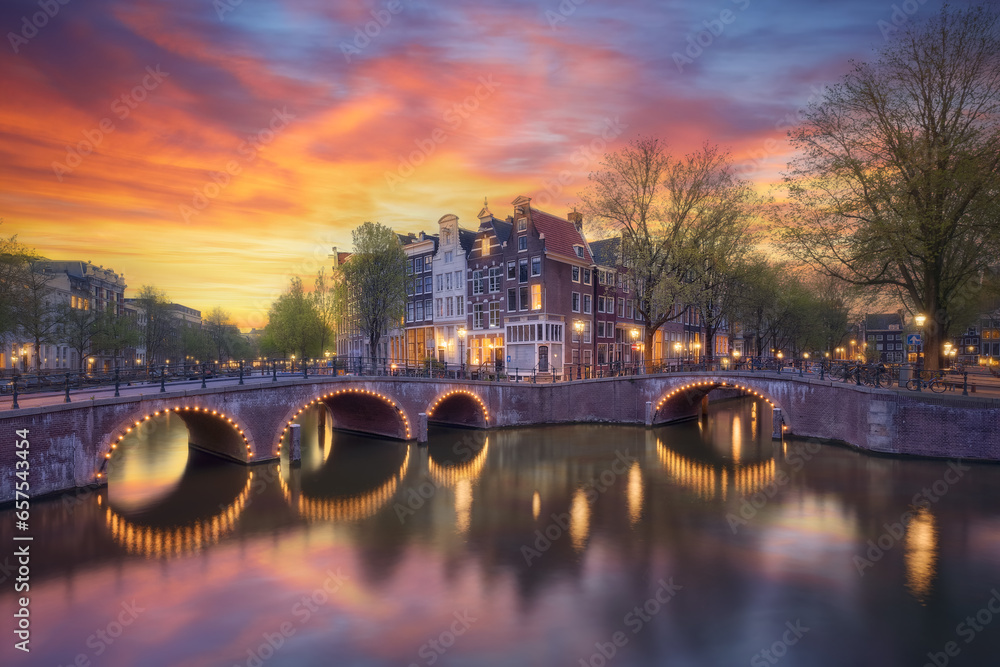 Panoramic view of the historic city center canals of Amsterdam at sunset. Traditional houses and bridges of Amsterdam town at Corner Keizersgracht and Leidsegracht. - obrazy, fototapety, plakaty 