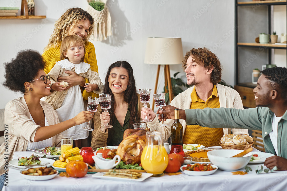 Happy Thanksgiving, cheerful multiethnic friends and family clinking glasses of wine near turkey Happy Thanksgiving, cheerful multiethnic friends and family clinking glasses of wine near turkey
