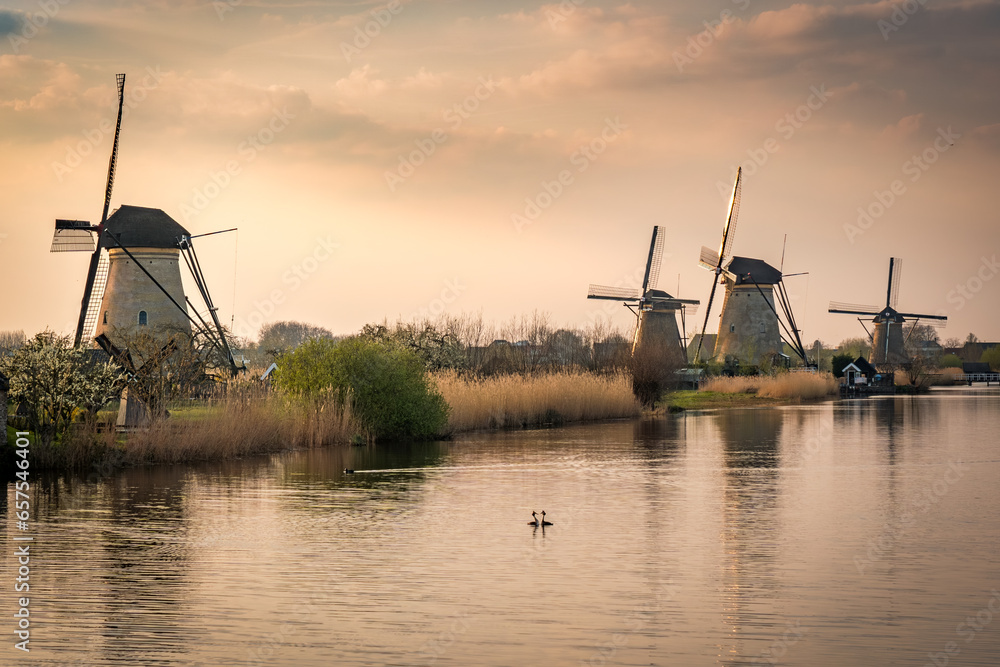 colorful sunset at a lake with windmills at kinderdijk
