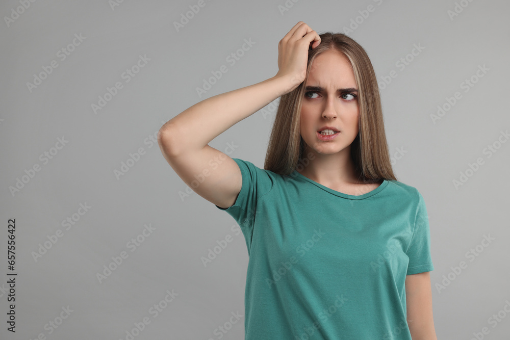 Embarrassed woman on grey background. Space for text