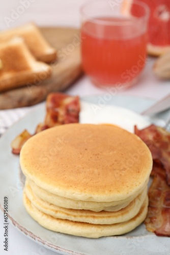 Plate with tasty pancakes on table, closeup