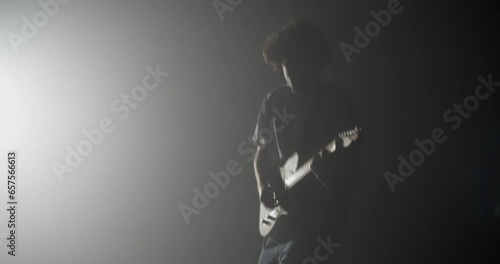 Silhouette of expressive rocker performing on electric guitar