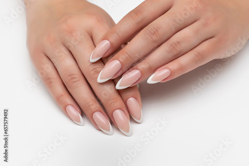 Wedding manicure on long sharp nails. White French manicure. Close-up on white background