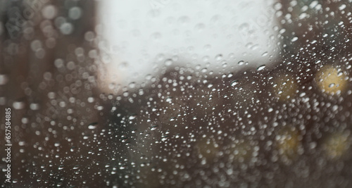 Raindrops on windowpane during a rainy day, capturing the tranquility and melancholy of nature's tears, evoking reflection and emotional depth