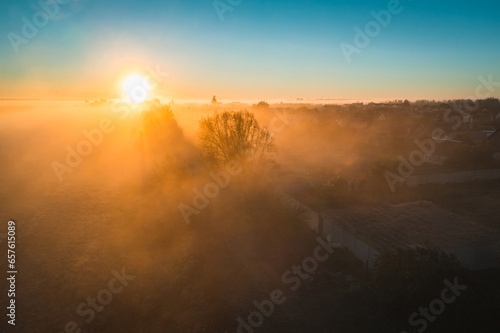 Silhouettes of wood and villages with houses in thick picturesque fog of autumn morning