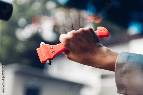 Obraz na plátně Woman use Safety Hammer and Seatbelt Cutter in Cars, break glass When emergency