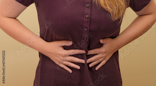 Kobieta trzymająca się za brzuch, ból brzucha przy zatruciu pokarmowym 