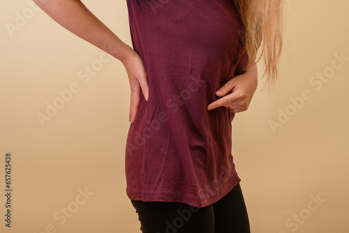 Kobieta stojąca bokiem pokazuje ból nerki 