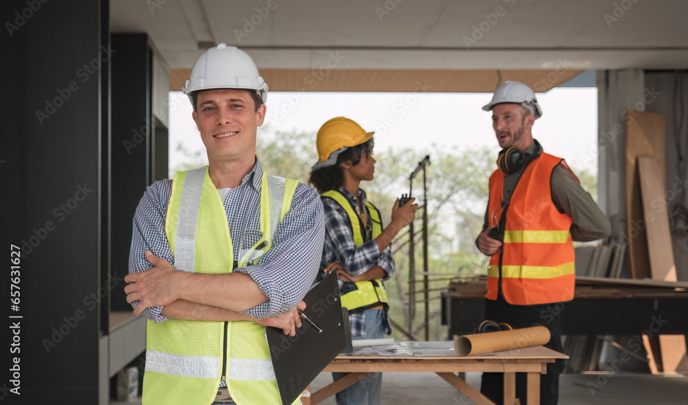 Portrait of an engineer standing and looking at the camera with a team of professional engineers meeting to plan a construction project. Portrait of an engineer standing and looking at the camera with a team of professional engineers meeting to plan a construction project.