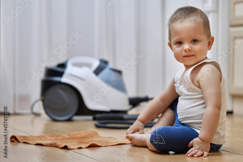little baby girl with a rag washing the tiled floor