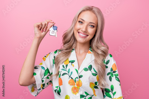 Photo of gorgeous successful young model girl blonde bought brand new flat holding her keys good ofer isolated on pink color background photo