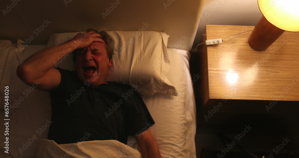Person waking up at night, turning bedside light ON, man stretching and getting up from bed