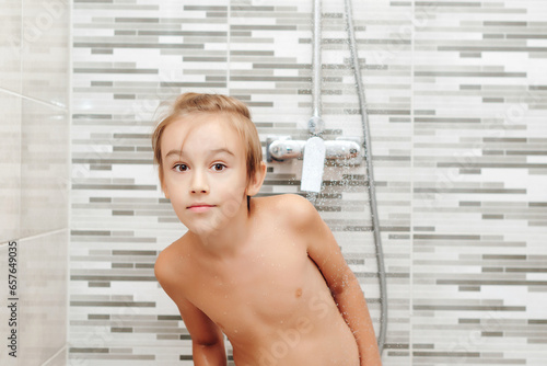 Boy washing himself in shower. Healthy childhood, lifestyle concept.