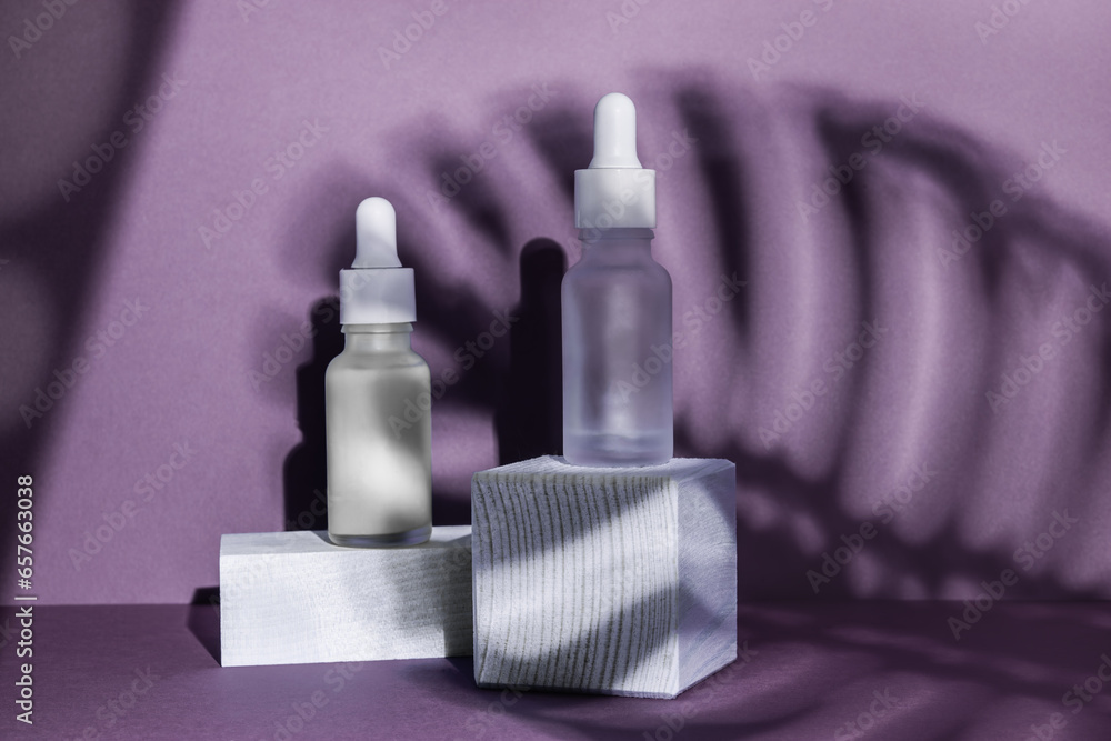 Minimalistic cosmetic still life. Two cosmetic product serum or oil mockups on geometric wooden podiums. Background for presentation of cosmetic with tropical leaf shadow Minimalistic cosmetic still life. Two cosmetic product serum or oil mockups on geometric wooden podiums. Background for presentation of cosmetic with tropical leaf shadow