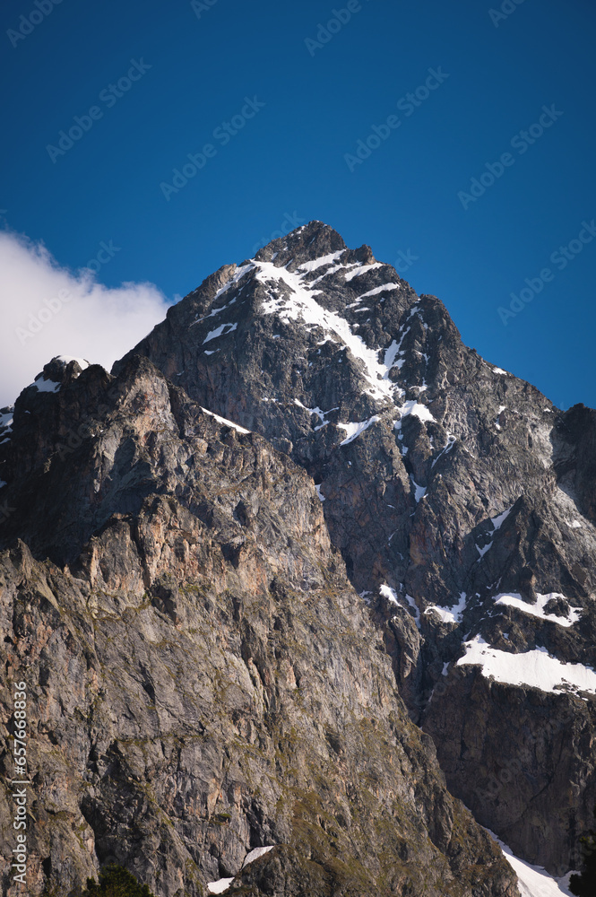 Caucasus mountains. Stone slopes of mountains with pieces of snow on a sunny day, close-up
