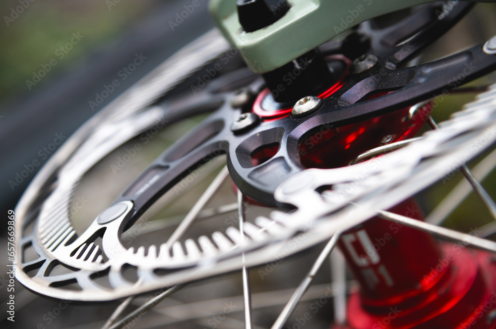 Fototapeta premium Close-up of a mountain bike element. Shallow depth of field frame detail and brake disc of mountain bike hydraulic brakes
