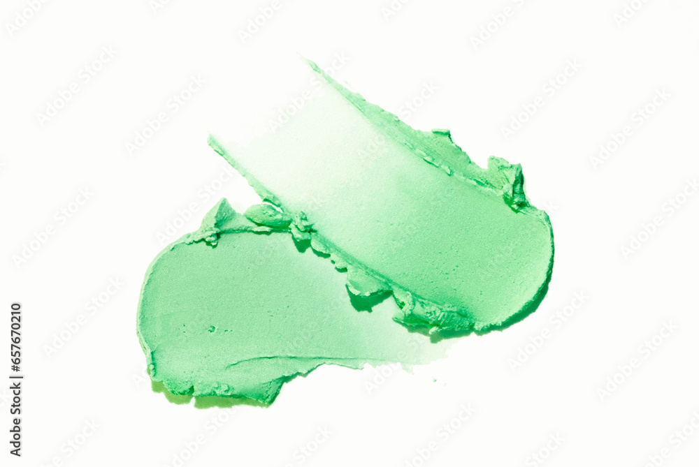 Smear of a green magnetic or charcoal mask on beige isolated background. Smudge texture brush stroke. Smear of a green magnetic or charcoal mask on beige isolated background. Smudge texture brush stroke.