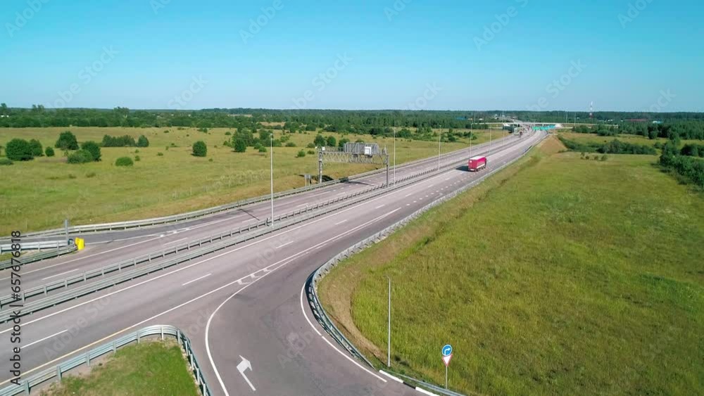 Aerial of highway through green meadows with traffic on it on a bright sunny day Aerial of highway through green meadows with traffic on it on a bright sunny day