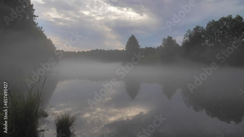 Unique turquoise karst lake near city of Kazan, Russia. Early morning scenery at the lake with mist over the surface