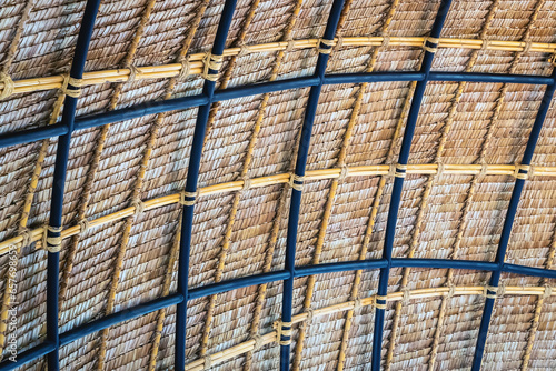 Beautiful thatched roof surface detail of mixed materials pattern structure by weave pile straw with steel bars. .Roof    made    of    straw. Pattern of under bamboo roof frame..Wooden thatched ceiling.