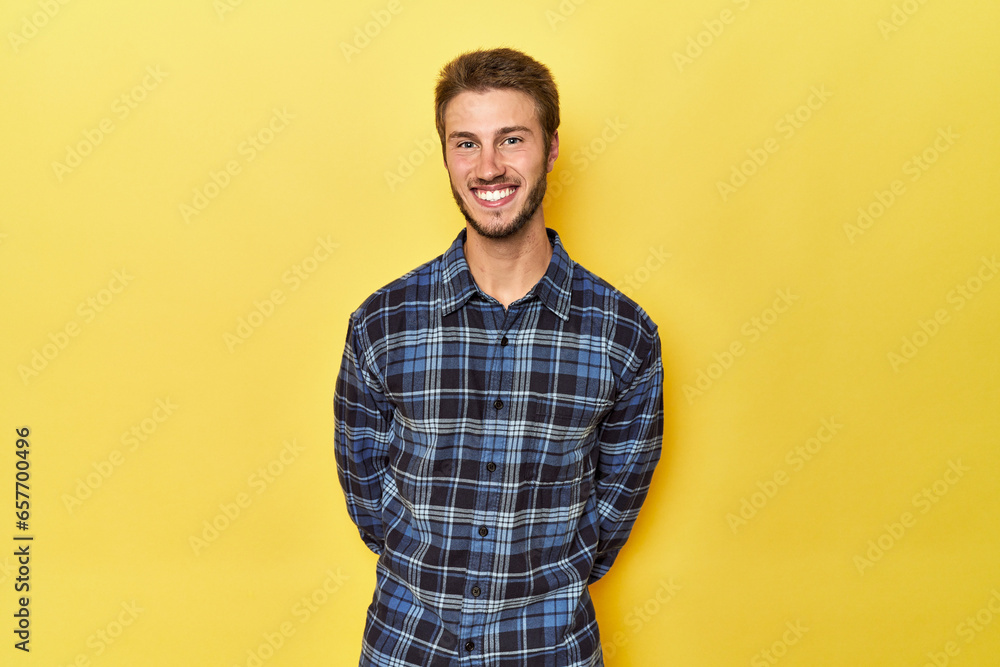 Young Caucasian man on a yellow studio background happy, smiling and cheerful. Young Caucasian man on a yellow studio background happy, smiling and cheerful.