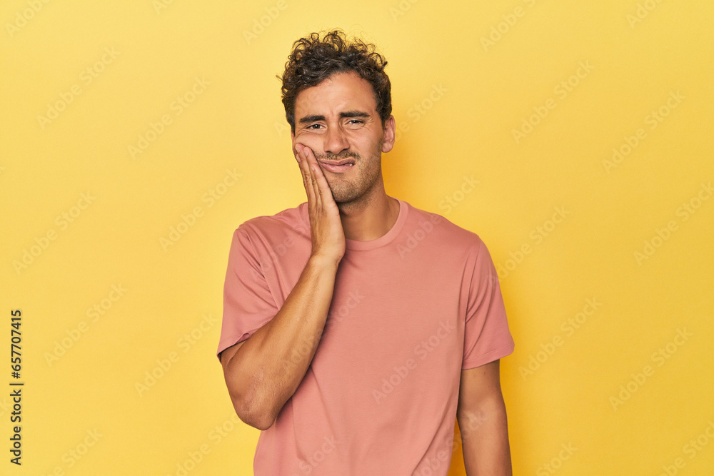 Young Latino man posing on yellow background having a strong teeth pain, molar ache. Young Latino man posing on yellow background having a strong teeth pain, molar ache.