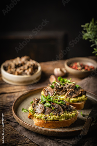 Toast avocado, mushrooms and microgreens whole grain sandwich. Vegetarian food. Vegan menu. Delicious breakfast or snack, Clean eating, dieting, vegan food concept.