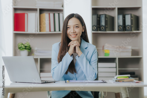 Happy Asian businesswoman working in modern office using laptop computer