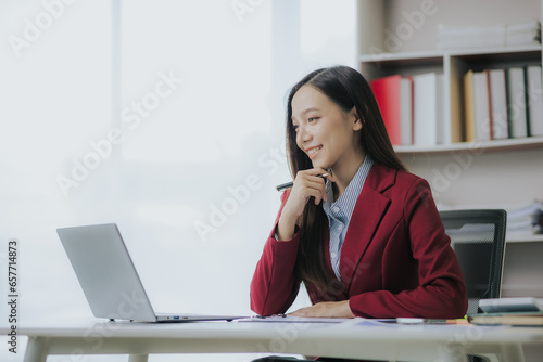 Asian businesswoman working with documents and smiling happily while working in the office Business success and celebration concept