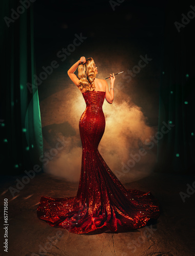 Sexy woman retro lady smoker holding cigarette mouthpiece in hands back rear view. art photo real people roar blonde girl red long shiny dress train. blond hair 20s old style classic room full smoke
